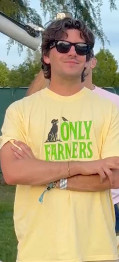 Person wearing a yellow 'Only Farmers' t-shirt with sunglasses and arms crossed outdoors.